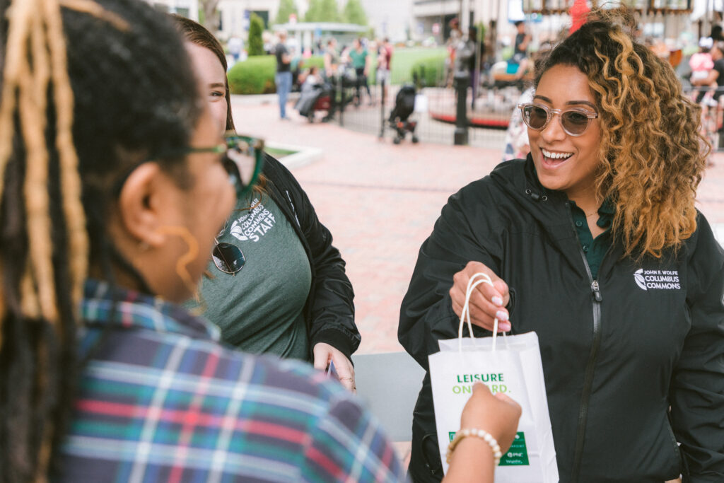 woman handing a bag to another woman