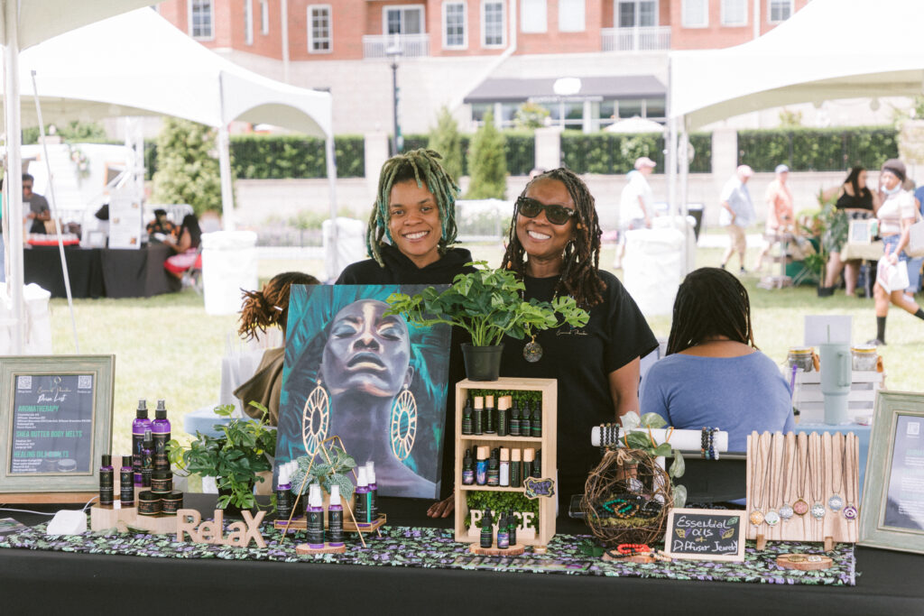 women selling their creations at a booth outside